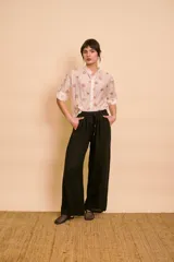 Camisa de seda color marfil con estampado floral pequeño, cuello mao y mangas cortas con presilla y botón para arremangar.