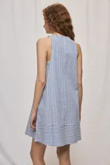 Vestido corto sin mangas con escote redondo y diseño evasé a rayas verticales celestes y blancas, con detalle de rayas horizontales en el ruedo.