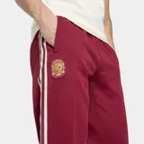 Pantalón deportivo Adidas de la selección de España, color bordó con las icónicas tres tiras blancas laterales. Presenta el escudo de la selección bordado en la pierna derecha y un corte clásico con ajuste cómodo.