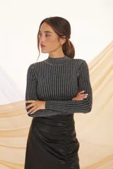 Sweater de punto con cuello alto, de color negro con lurex plateado y diseño a rayas verticales.
