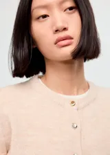 Cardigan de punto de corte recto con cuello redondo, manga larga y cierre frontal con botones dorados.