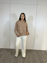 Buzo de tejido de punto color camel, con cuello alto cruzado y cierre lateral con botón. Presenta un corte relajado y mangas largas con terminaciones acanaladas.