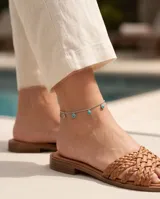 Tobillera de cadena de acero con dijes circulares colgantes con piedra turquesa.