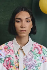 Camisa de corte oversize con mangas largas y puños abotonados. Presenta un diseño bicolor con cuerpo blanco y un canesú delantero con estampado floral multicolor.
