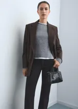 Pantalón de jean estilo flare de tiro medio, con cierre frontal de cremallera y botón, diseño de cinco bolsillos y acabado con bajo desflecado.