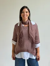 Sweater de punto color marrón chocolate con cuello redondo, mangas tres cuartos y diseño asimétrico. Incluye un pañuelo a juego con detalles de puntilla en los bordes.