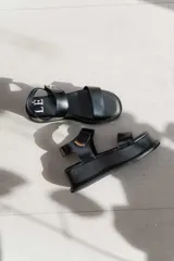 Sandalias de plataforma color negro, con diseño de dos tiras anchas en el empeine y cierre con velcro en el tobillo. Presentan una suela de plataforma alta y liviana.