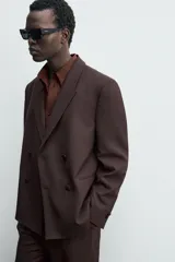 Blazer de traje cruzada de corte regular fit, color marrón oscuro, con solapas de muesca, bolsillos de doble vivo en la cadera y cierre frontal de botonadura doble.