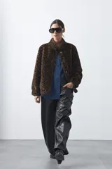 Pantalón de cuero sintético con corte barrel, de silueta relajada con volumen en las piernas y botamanga ligeramente entallada.