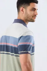 Remera polo de manga corta con diseño a rayas horizontales en tonos beige, celeste, rosado, azul marino y verde. Cuenta con cuello polo y cierre frontal con botones.