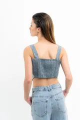 Conjunto de top corto y falda corta color verde agua. El top es de breteles anchos, corte recto y con volados verticales y botones decorativos en el frente. La falda es de corte recto con volados en el ruedo.