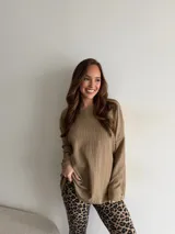 Conjunto compuesto por buzo oversize texturizado de manga larga color marrón claro y calzas ajustadas con estampado animal print de leopardo.