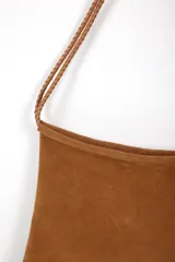 Cartera bandolera negra con flecos largos en la parte inferior y correa trenzada con hombrera.