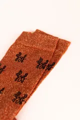 Calcetines color cobre con glitter y logo de la marca en negro.