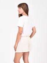 Remera blanca de manga corta con cuello redondo y un estampado frontal de un jarrón azul a rayas con flores rosadas.