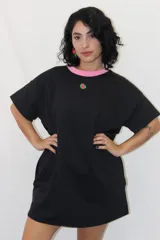 Remerón tipo vestido de corte holgado y manga corta, con cuello redondo en contraste y bolsillos laterales. Presenta un pequeño aplique decorativo en el pecho.