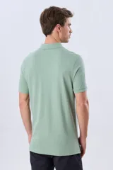 Remera polo de piqué de algodón color azul, de manga corta, con cuello camisero, cierre frontal de dos botones y pequeño logo bordado en el pecho.