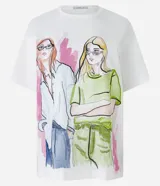 Remera de algodón color blanco con estampado de figuras femeninas de colores. Tiene cuello redondo y mangas cortas.