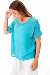 Blusa celeste de algodón con escote redondo y mangas cortas con dobladillo.