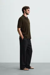 Polo de tejido canalé en color blanco, con cuello solapa y abertura frontal en V, de manga corta y corte regular.