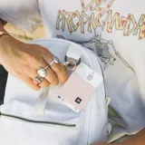 Billetera elástica color rosa claro con logo de la marca en etiqueta negra.