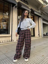 Pantalón de corte holgado tipo barrel con diseño de cuadros en tonos bordó, negro y blanco. Confeccionado en tela viyela, cuenta con cintura elástica y puños ajustados en los tobillos.