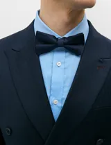 Ambo de doble abotonadura color azul marino, confeccionado en tejido con spandex. Saco de solapas en punta, hombros estructurados y bolsillos con solapa. Pantalón de corte recto con pinza frontal.