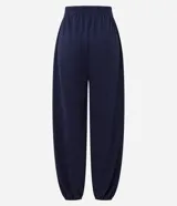 Pantalón largo femenino texturizado color azul marino, modelo aladim, con volumen amplio en las piernas y estrechamiento en el ruedo. Posee cintura elástica incorporada y pliegues delanteros.