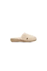 Pantuflas tipo mule de tela de rizo color gris, con cierre ajustable de velcro en el lateral y suela de goma negra con soporte biomecánico.