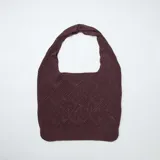 Bolso tipo shopper de ganchillo en color marrón oscuro, con diseño de tejido texturizado en rombos y asa integrada para el hombro.