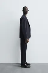 Blazer de corte regular fit confeccionado en tejido con lana. Presenta cuello con solapas de muesca, cierre frontal de un botón, bolsillos de vivo en el pecho y en la cadera, y aberturas en la espalda.