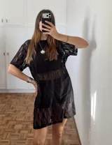 Vestido tipo remerón de encaje negro con diseño floral, de corte recto y holgado, con mangas cortas y cuello redondo.