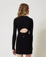 Minifalda negra acampanada de punto con detalle de hebilla plateada en la cintura.