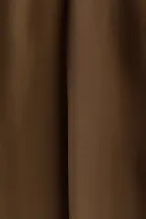Pantalón sastrero de corte ancho, color marrón, con pinzas frontales, trabillas para cinturón y raya marcada en las piernas.