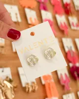 Par de aros pequeños con forma de flor con pétalos blancos y borde dorado.