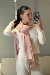 Bufanda rectangular de tejido suave con diseño de patrón escocés en tonos rosado y blanco, terminada con flecos en los extremos.