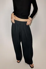 Pantalón fluido de tiro medio, confeccionado en mezcla de modal, con cintura elástica ajustable mediante cordones. Presenta pinzas en el delantero, bolsillos laterales ocultos y bajo ajustable con trabilla y botón a presión.