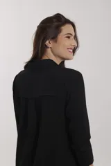 Vestido camisero midi con estampado floral en tonos naranja, rosa y fucsia. Tiene cuello camisero, mangas 3/4 y aberturas laterales.