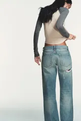 Jeans de tiro bajo y cinco bolsillos, de pierna ancha y larga. Cuenta con cierre frontal con cremallera y botón metálico.
