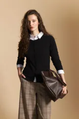 Cardigan negro de tejido suave y liviano, con cierre frontal abotonado y cuello redondo.