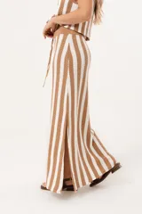 Falda larga tejida a rayas verticales color beige y blanco, con pretina elástica y tajos laterales.
