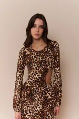 Vestido midi al cuerpo con estampado animal print, mangas 3/4 acampanadas, cut out en la cintura y tajo lateral.
