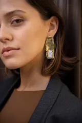 Aros colgantes de bronce reticulado con base irregular y piedra celeste redonda.