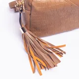 Bandolera color khaki con diseño combinado de textura lisa y efecto croco en el frente. Incluye una correa ajustable y un detalle de borla decorativa con herrajes dorados.