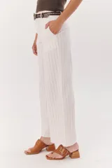 Sandalia color beige con tira ancha de cuero sobre el empeine, hebilla metálica plateada y taco geométrico de madera.