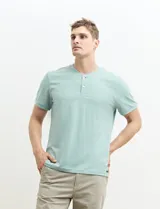 Remera tipo henley de manga corta, color beige, con cuello redondo y cartera de botones frontal.