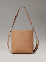 Cartera tipo saco color tostado de cuero sintético granulado, con correa de hombro ajustable de cuero sintético y correa bandolera ajustable de jacquard con logo.