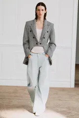 Blazer Zara Woman Collection de corte asimétrico con estampado de cuadros vichy en blanco y negro. Presenta cuello solapa, cierre frontal con botones y un diseño de bajo irregular con abertura central.