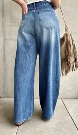 Jean de denim azul de tiro alto, con silueta barrel de corte ancho y relajado.