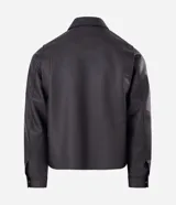 Campera de estilo urbano confeccionada en poliuretano con acabado lavado y textura que imita el cuero. Presenta cuello inglés, cierre frontal con cremallera, vista con botones y bolsillos delanteros amplios.